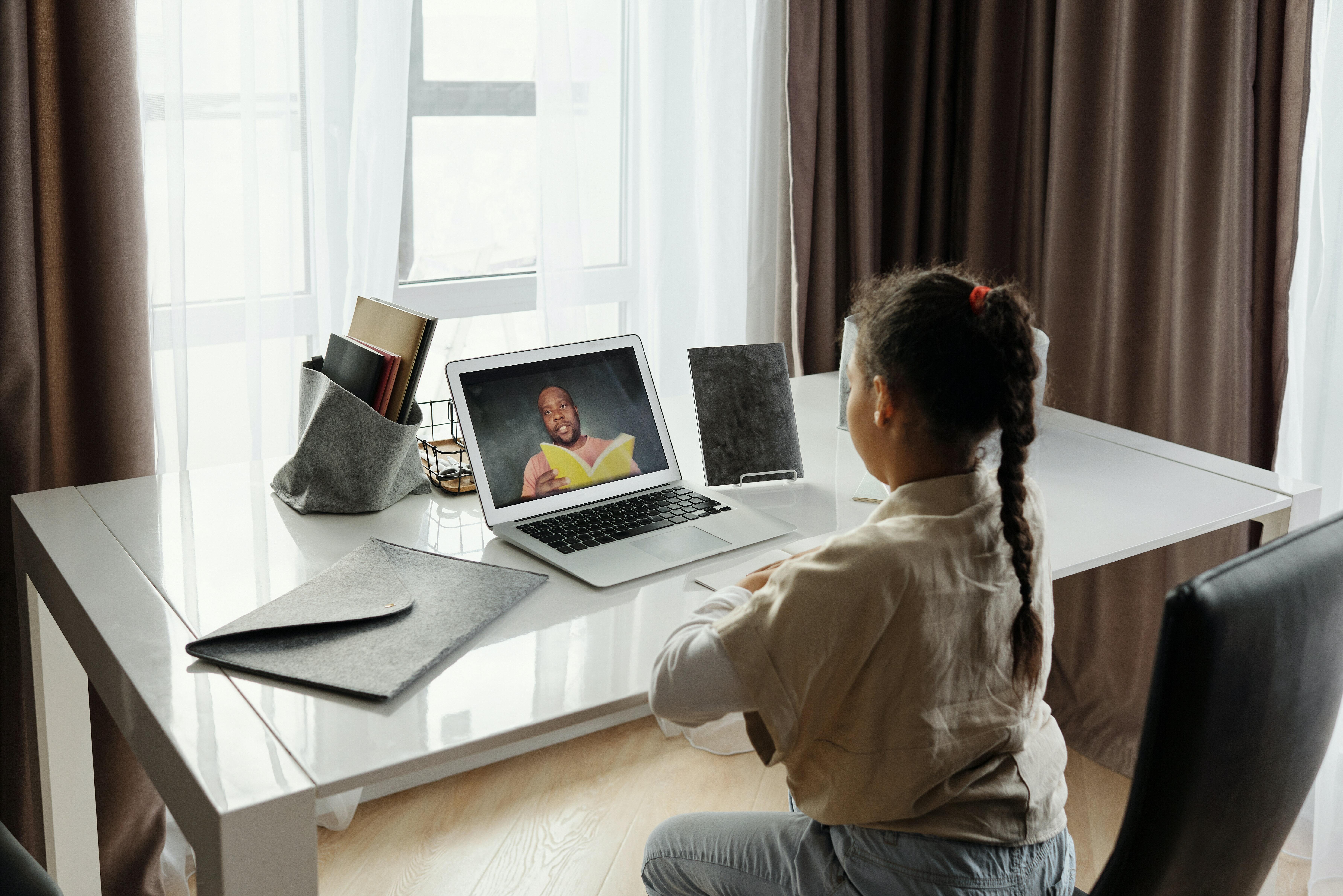 A child in an online meeting with a tutor.