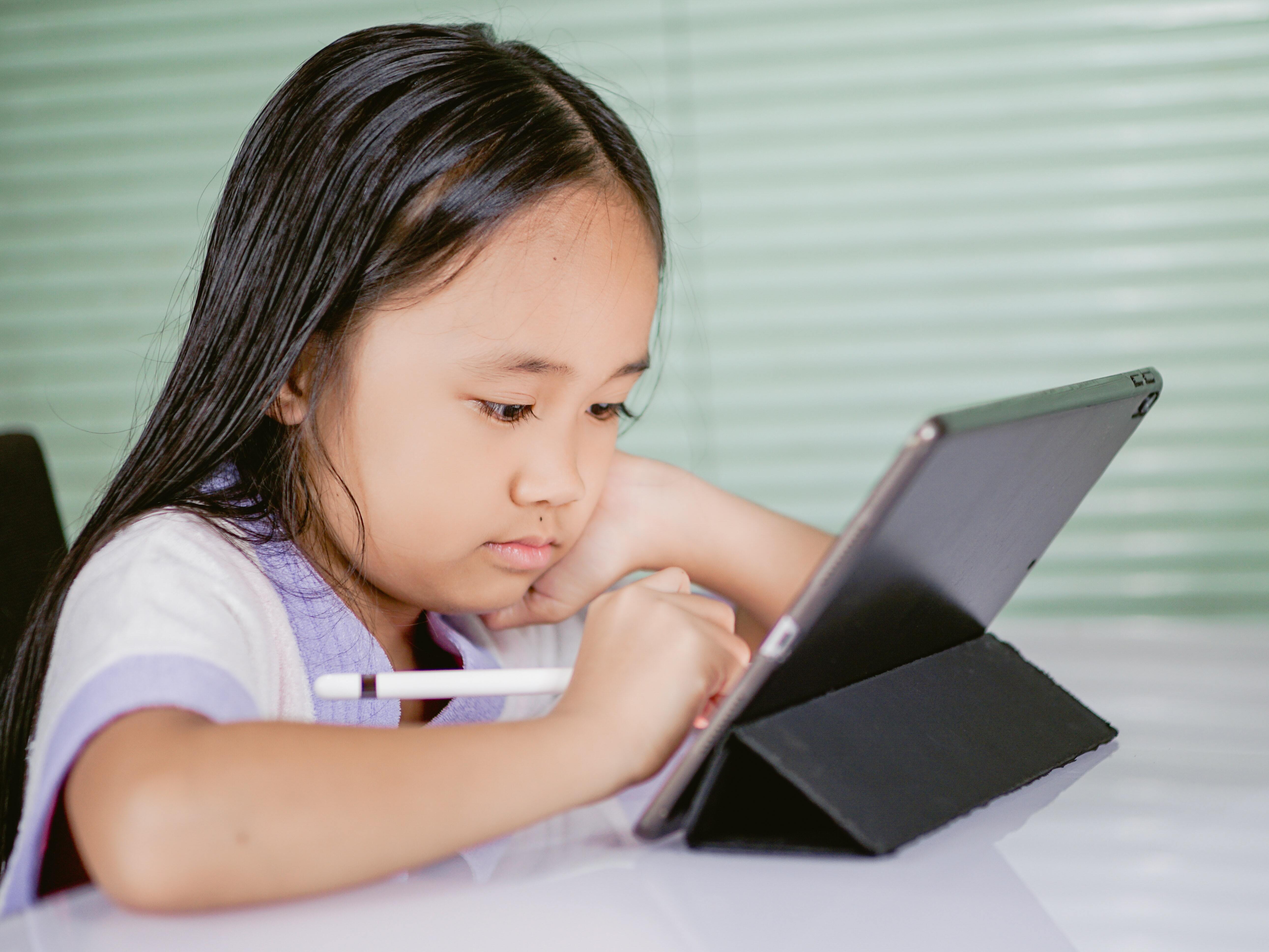 A child using  tablet on a desk