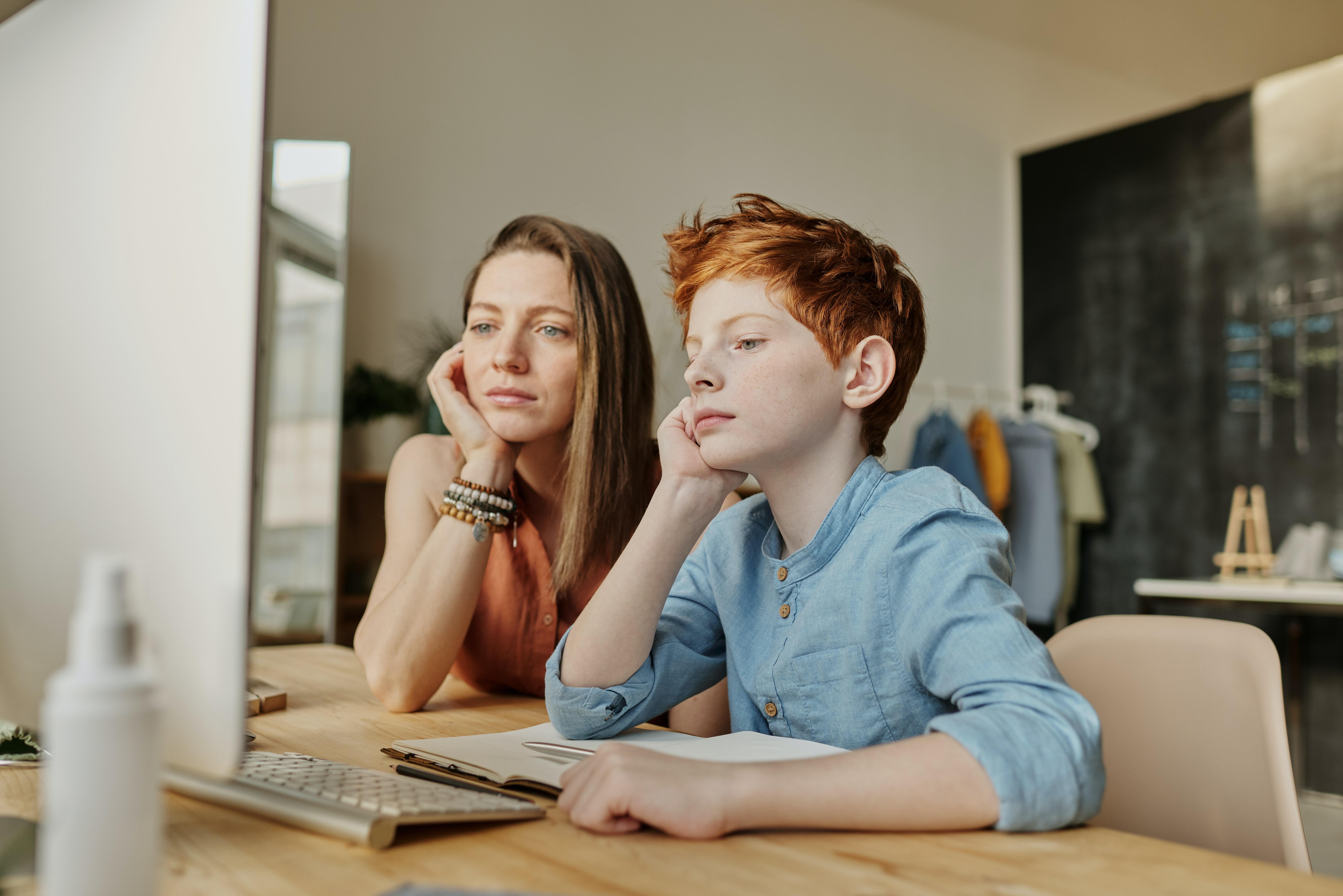 A mother and a child staring at the computer screen