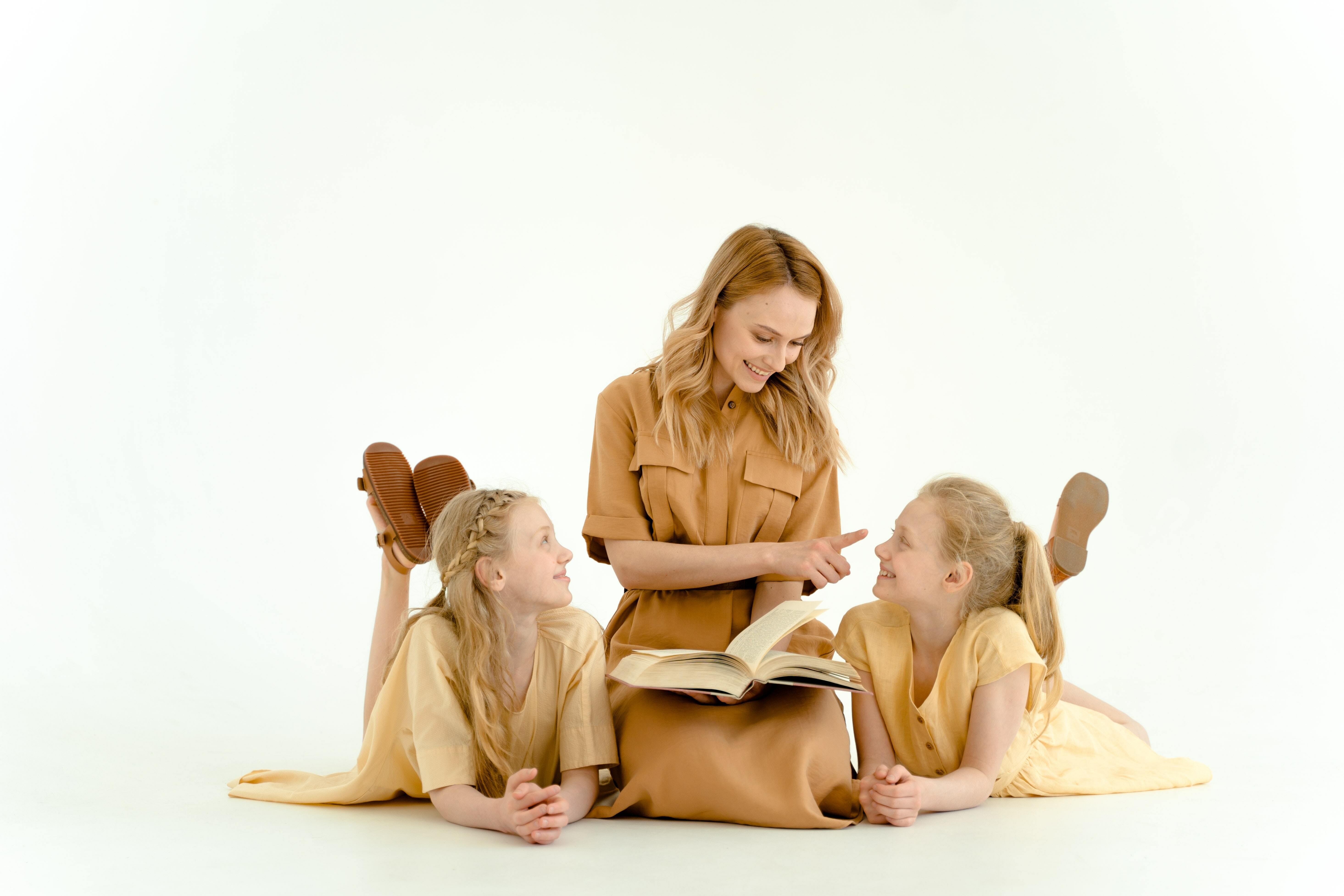 A woman and 2 children reading