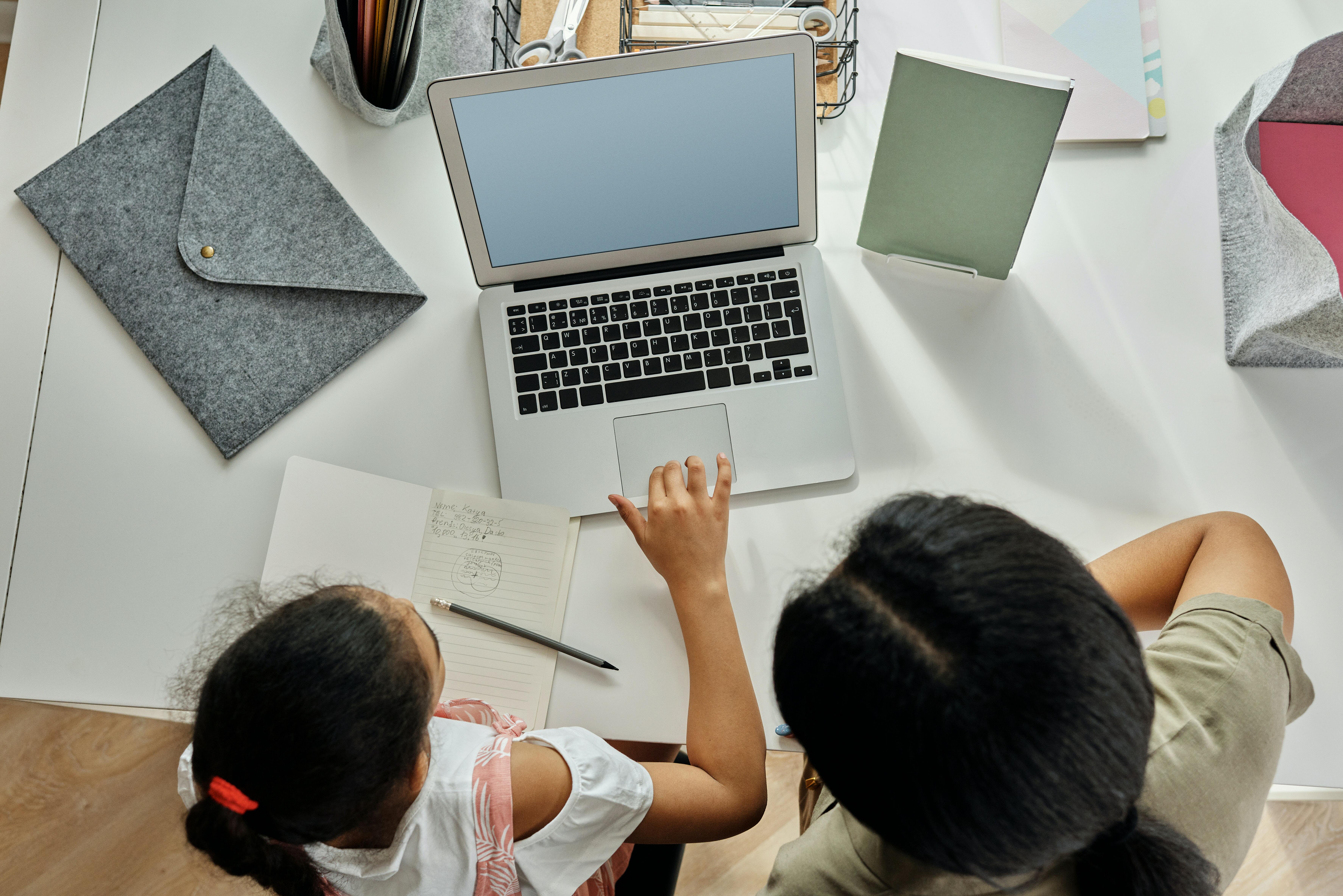 A woman homeschooling a female child