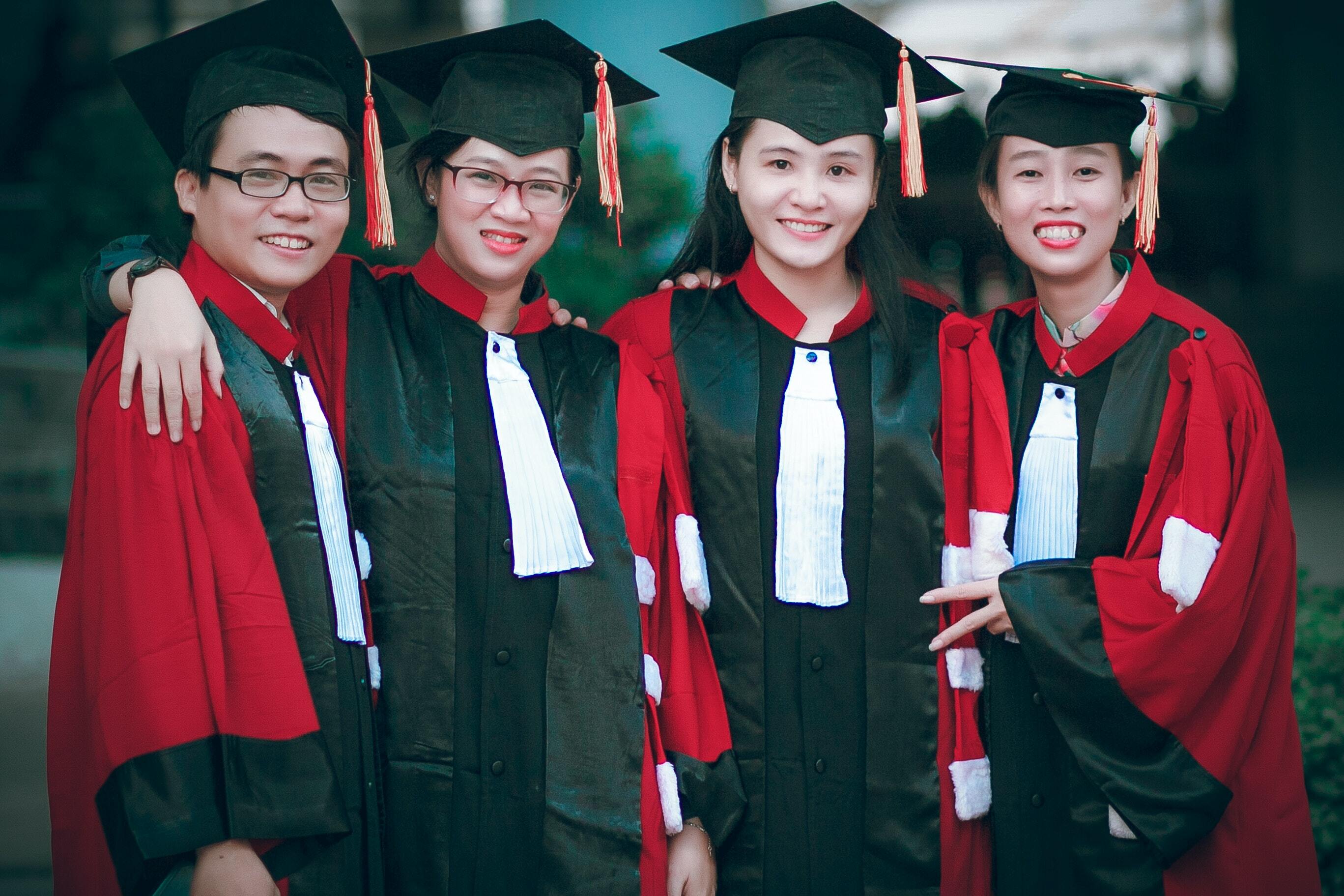 Graduating children wearing graduation gown