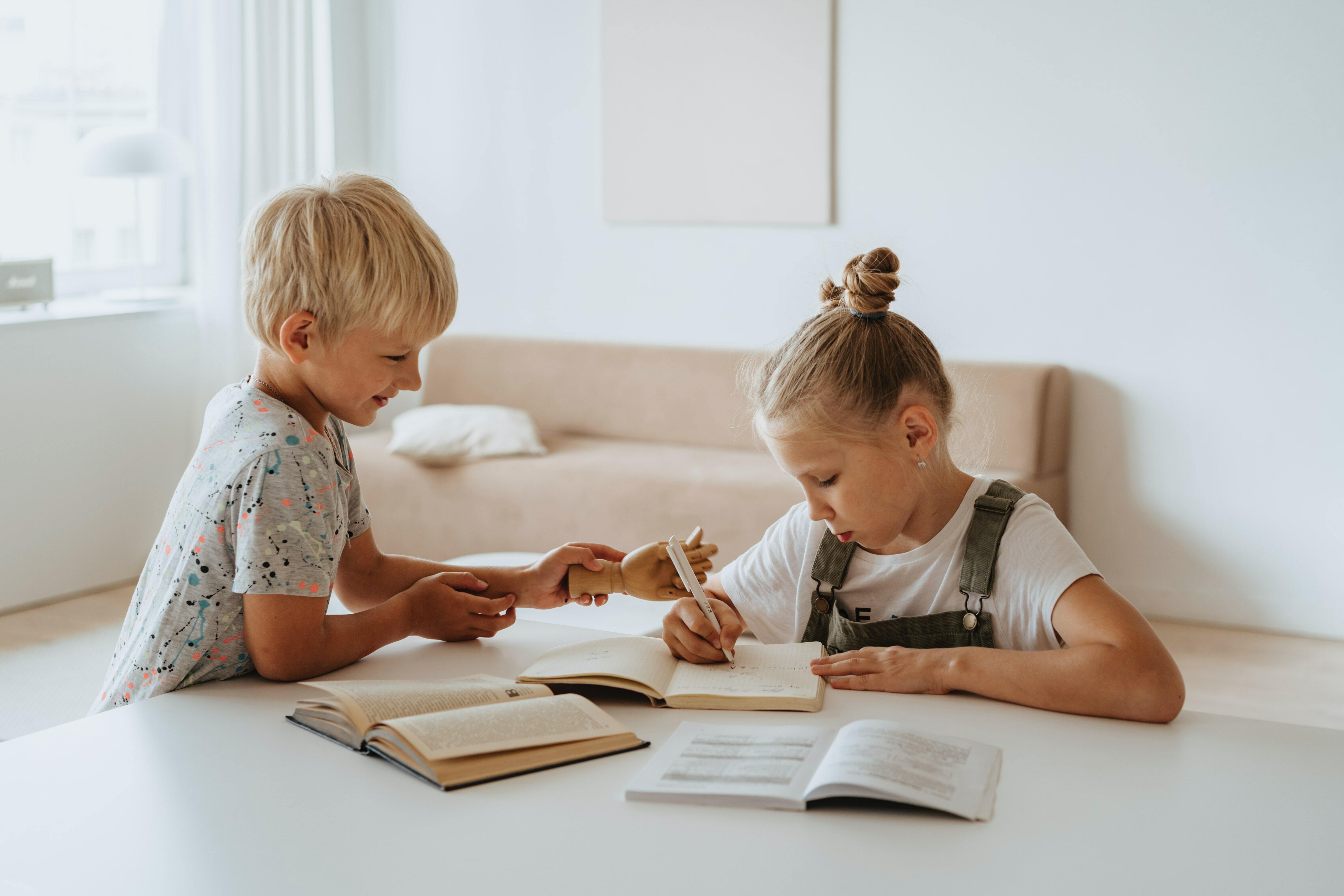 Two children writing on a table