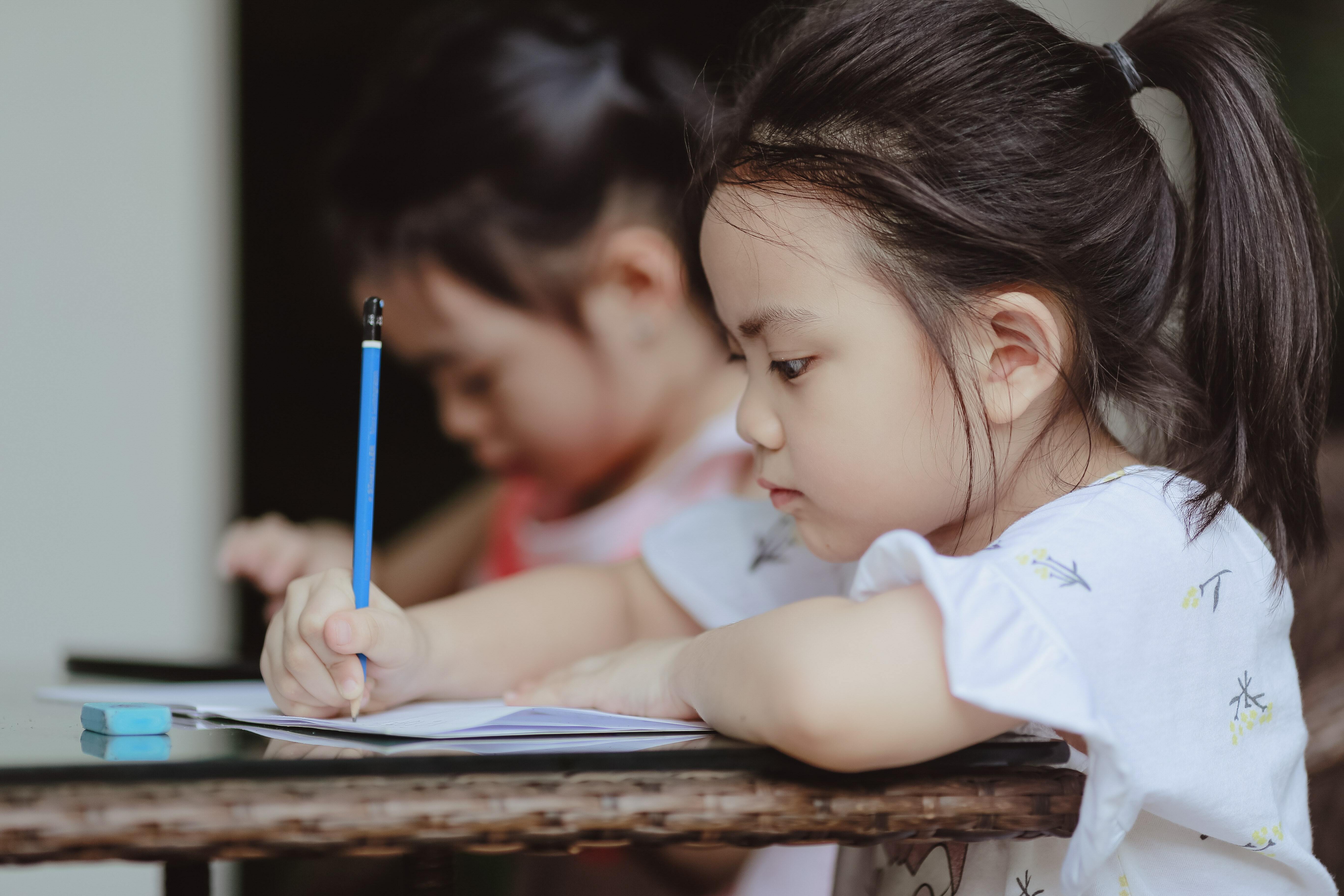 Two children writing
