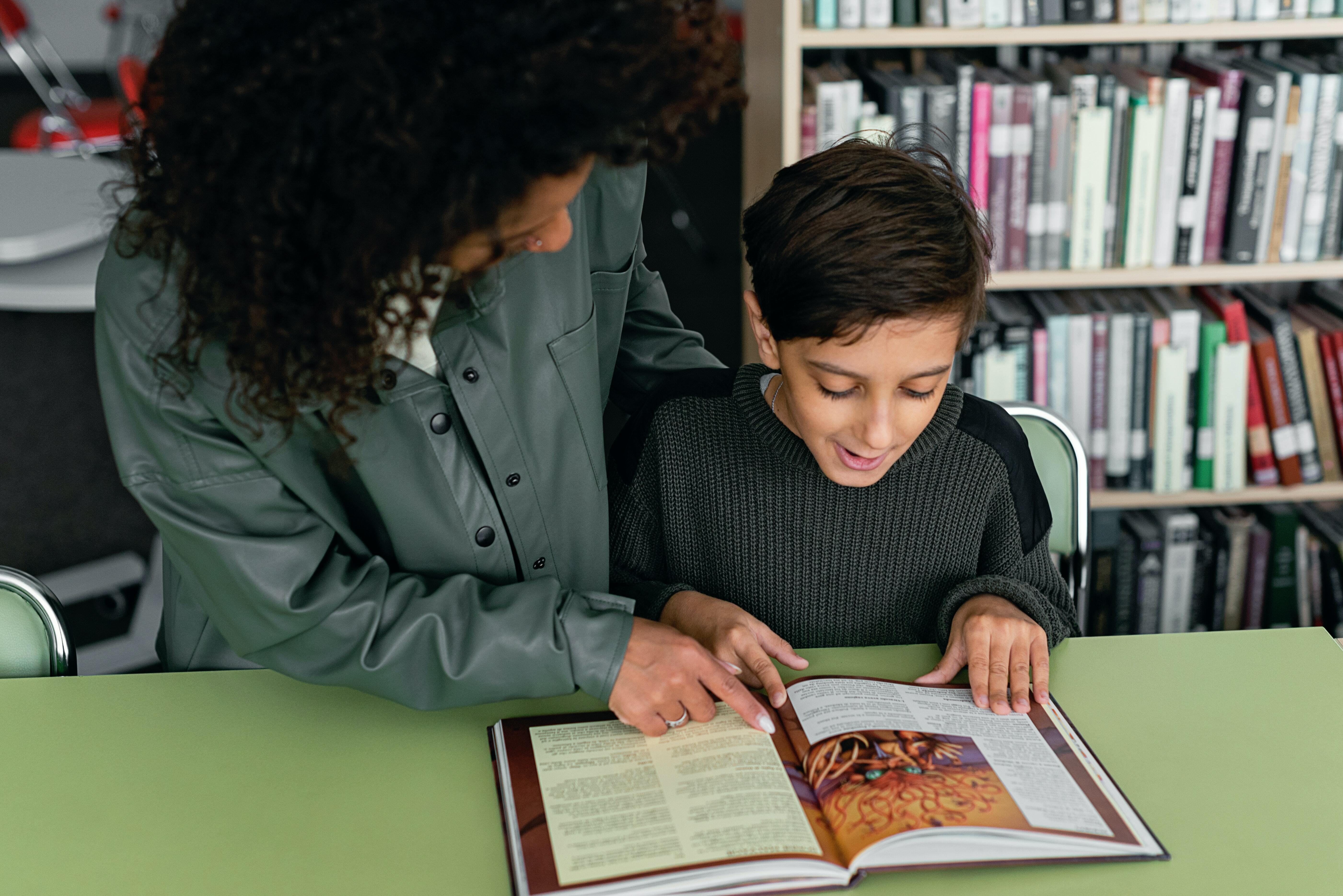 A woman and a child reading a book in a library
