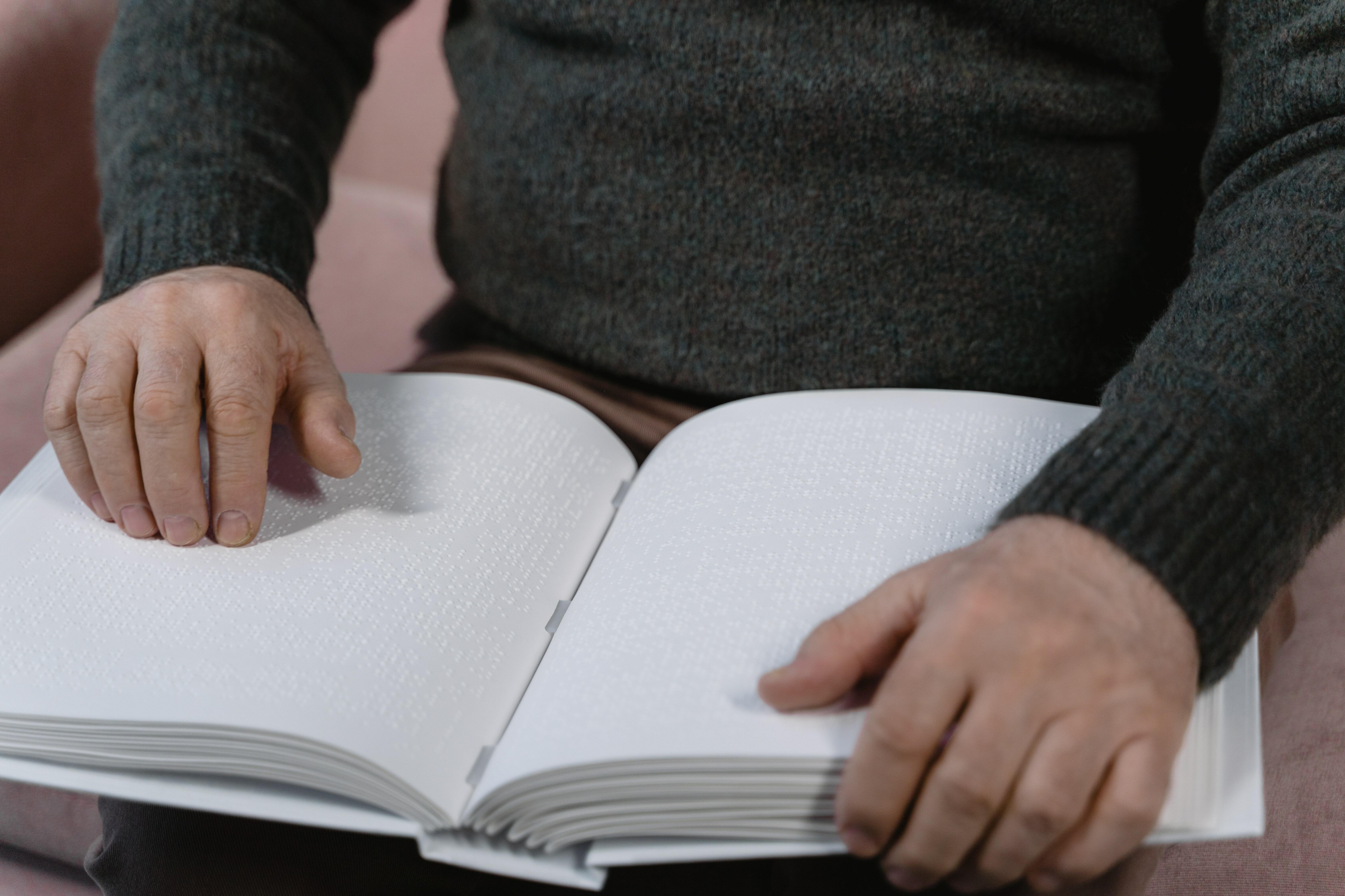Person Reading a Book Using Braille System