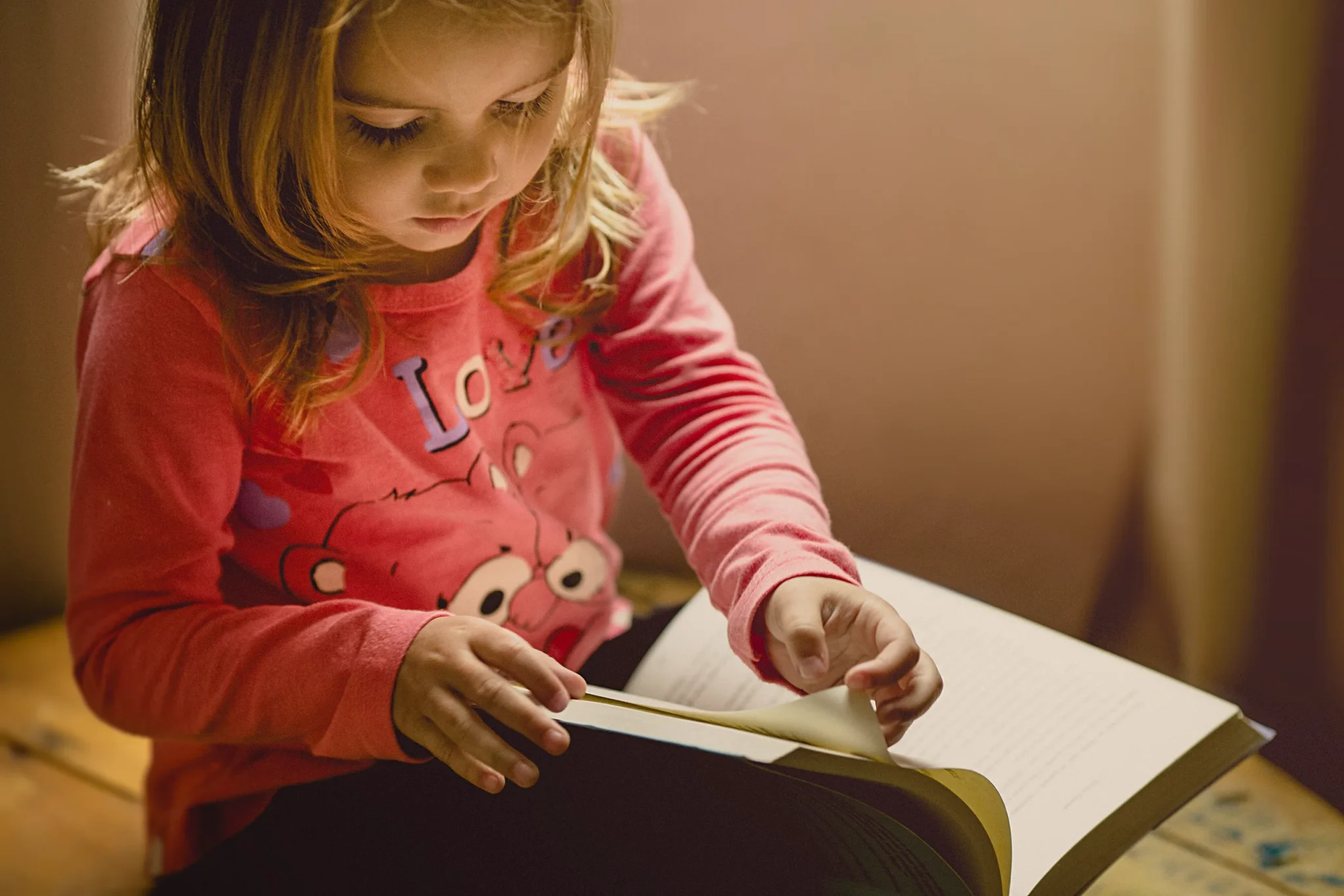 A little child turning pages of a book