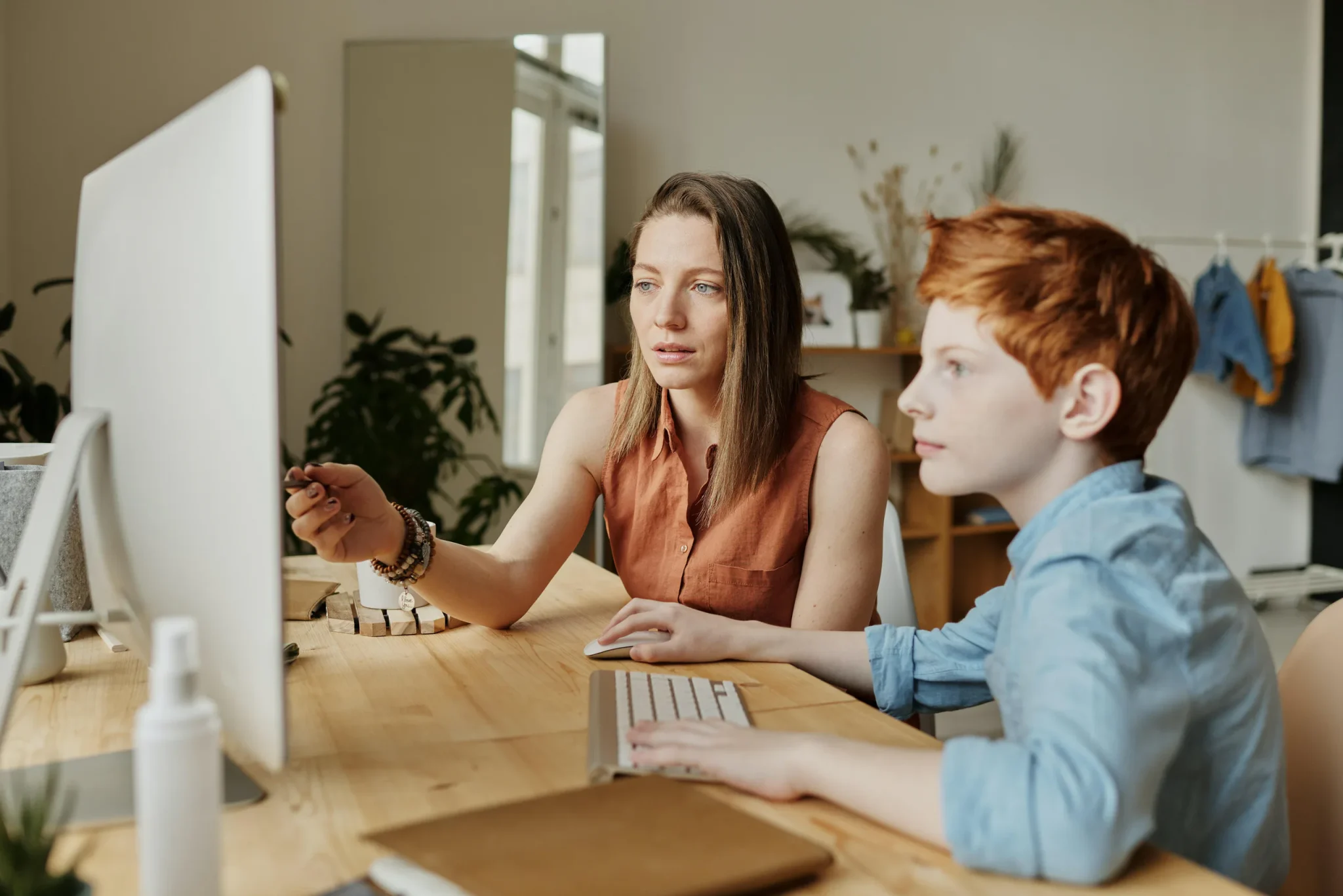 A woman and a child staring at the desktop screen