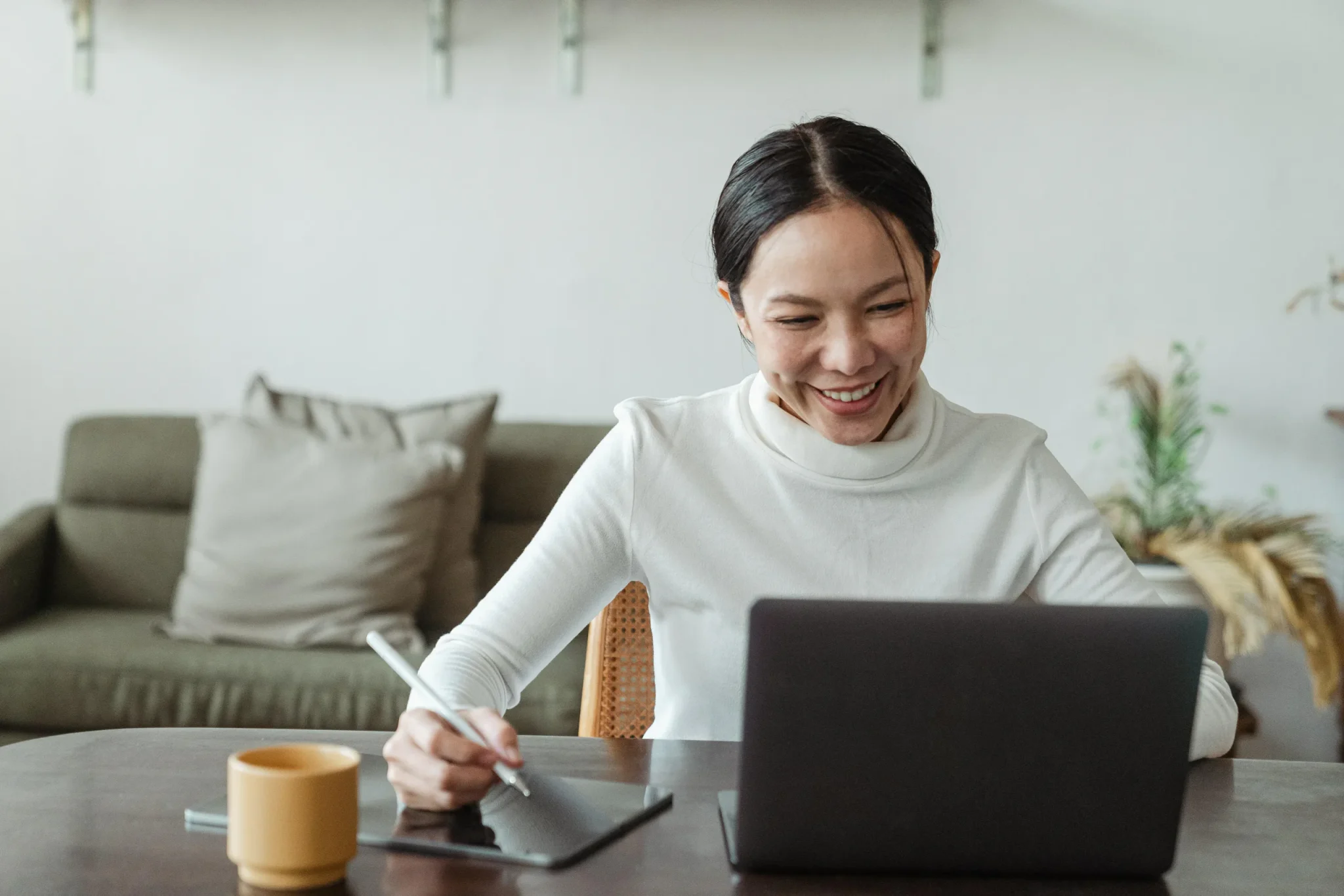 A woman writing in front of a laptop