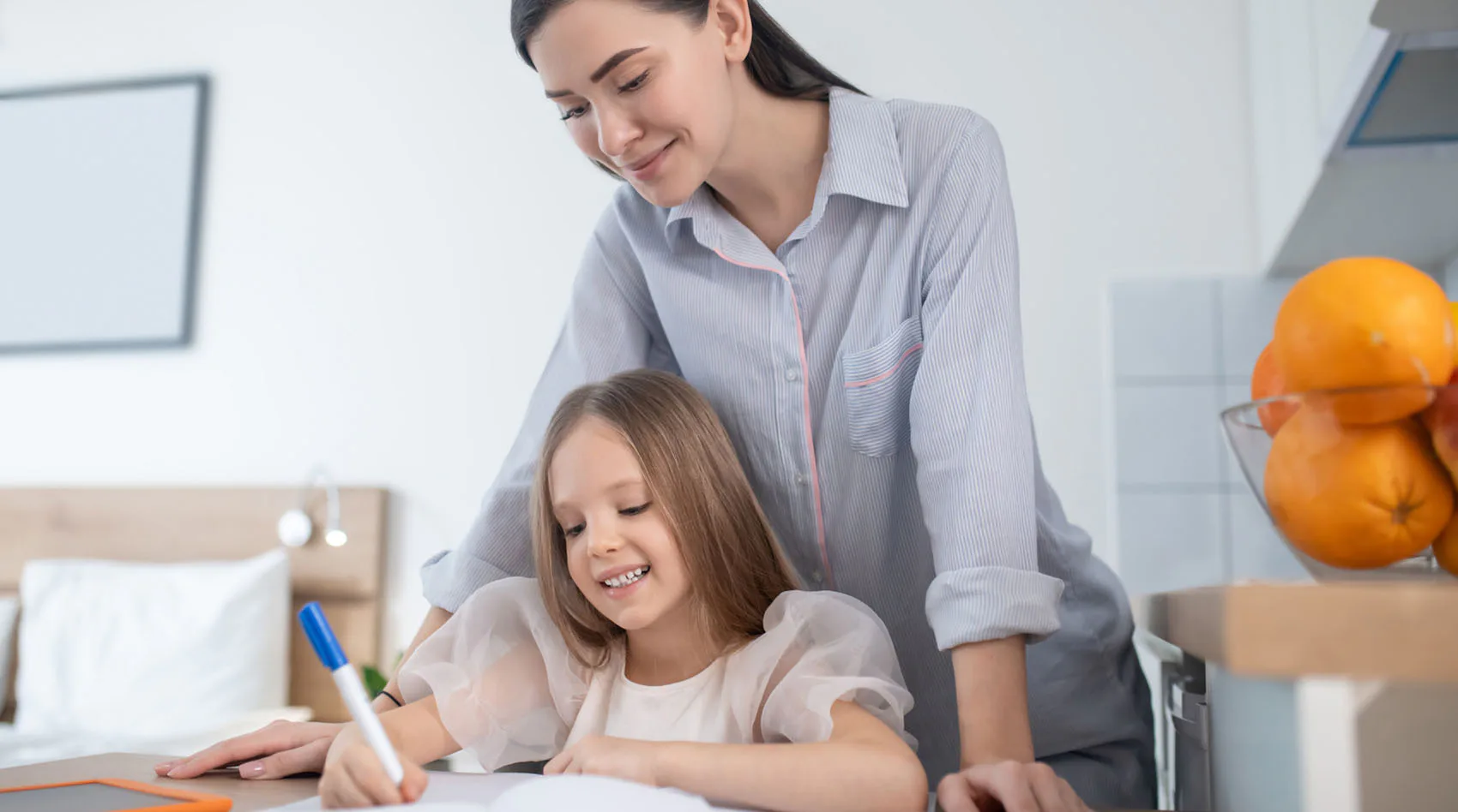 girl writes and woman watches