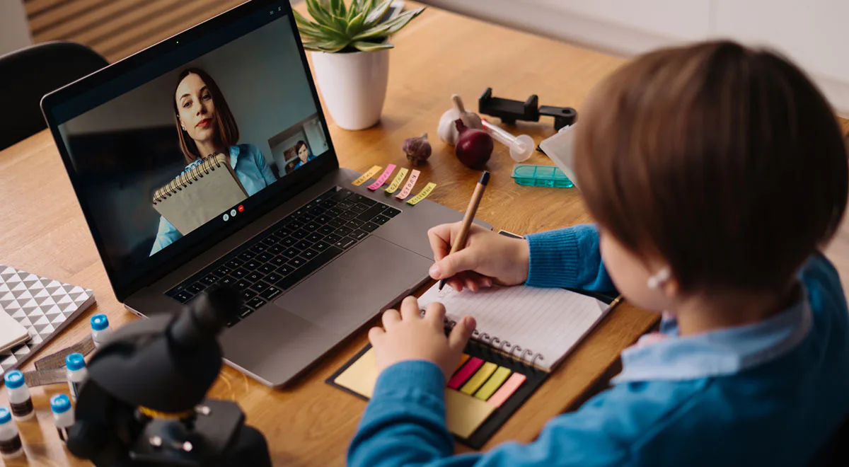 child watches online lecture and takes notes