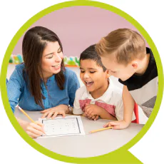 woman and two boys writing