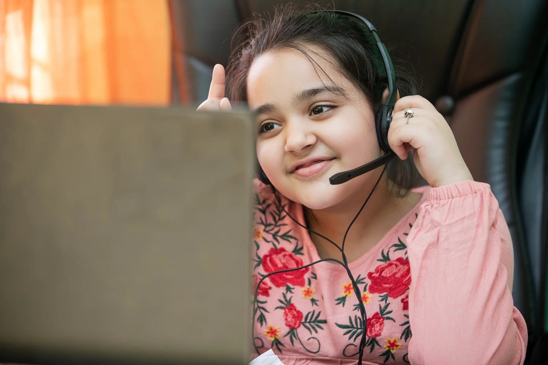 A child smiling in front of a laptop