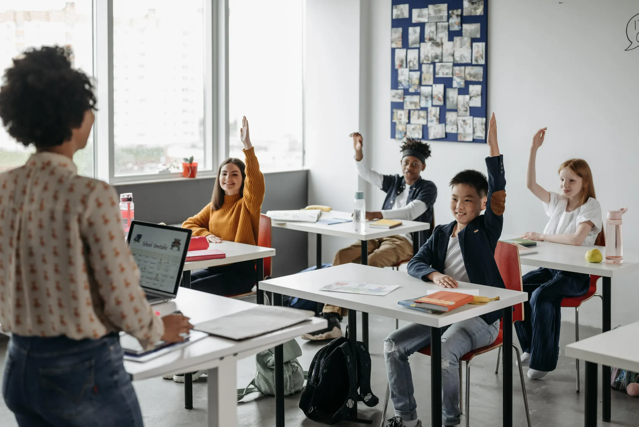 Children raising hands in class