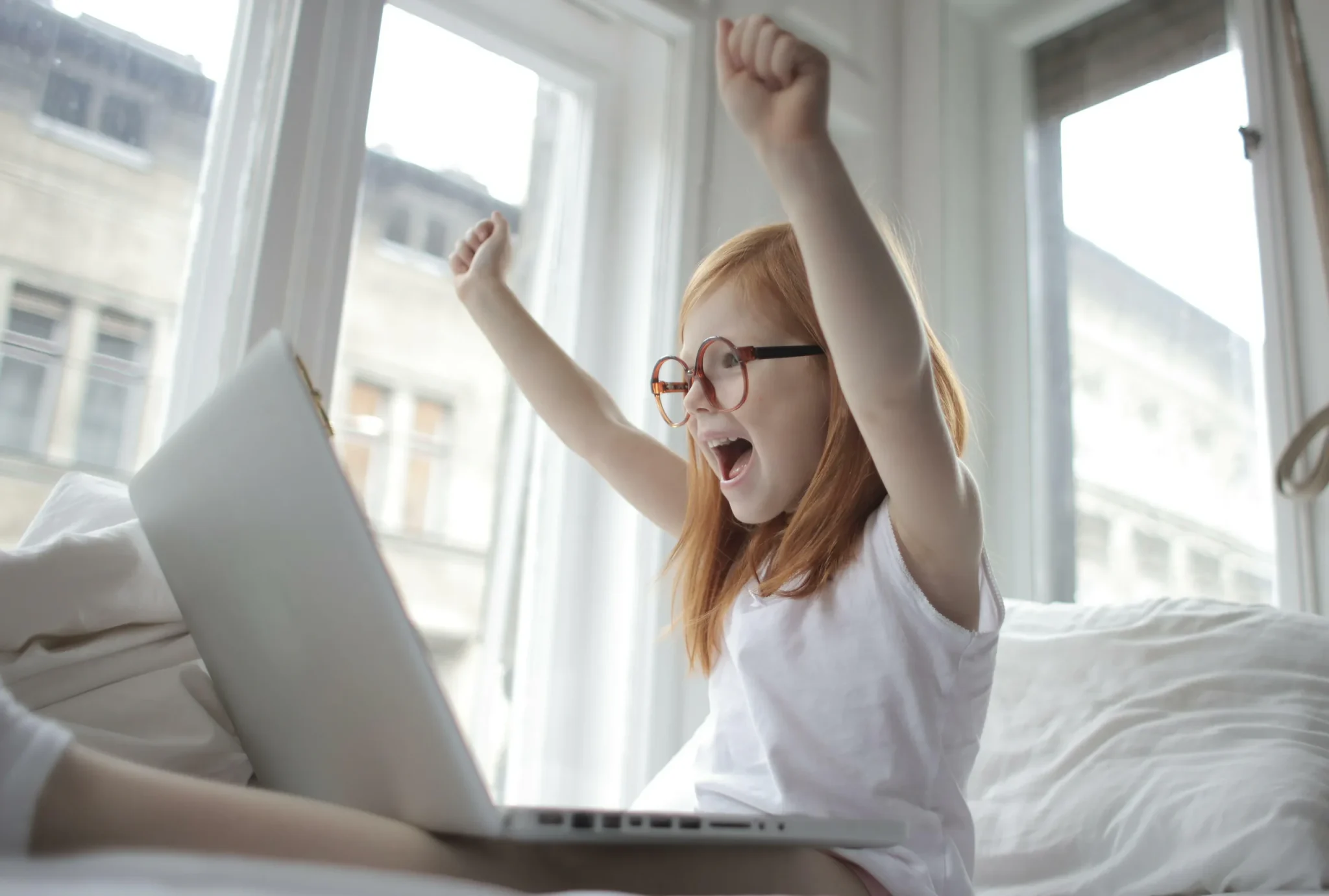 A happy child behind a laptop