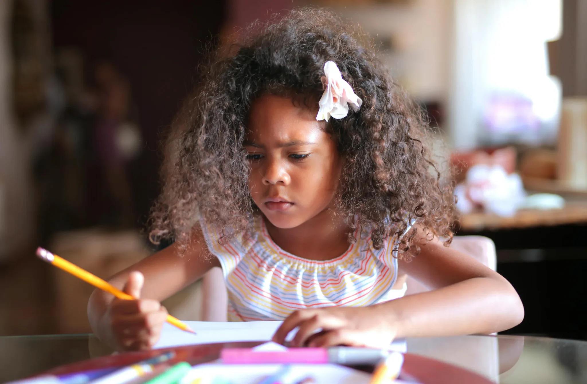 A child holding a pencil with book in front