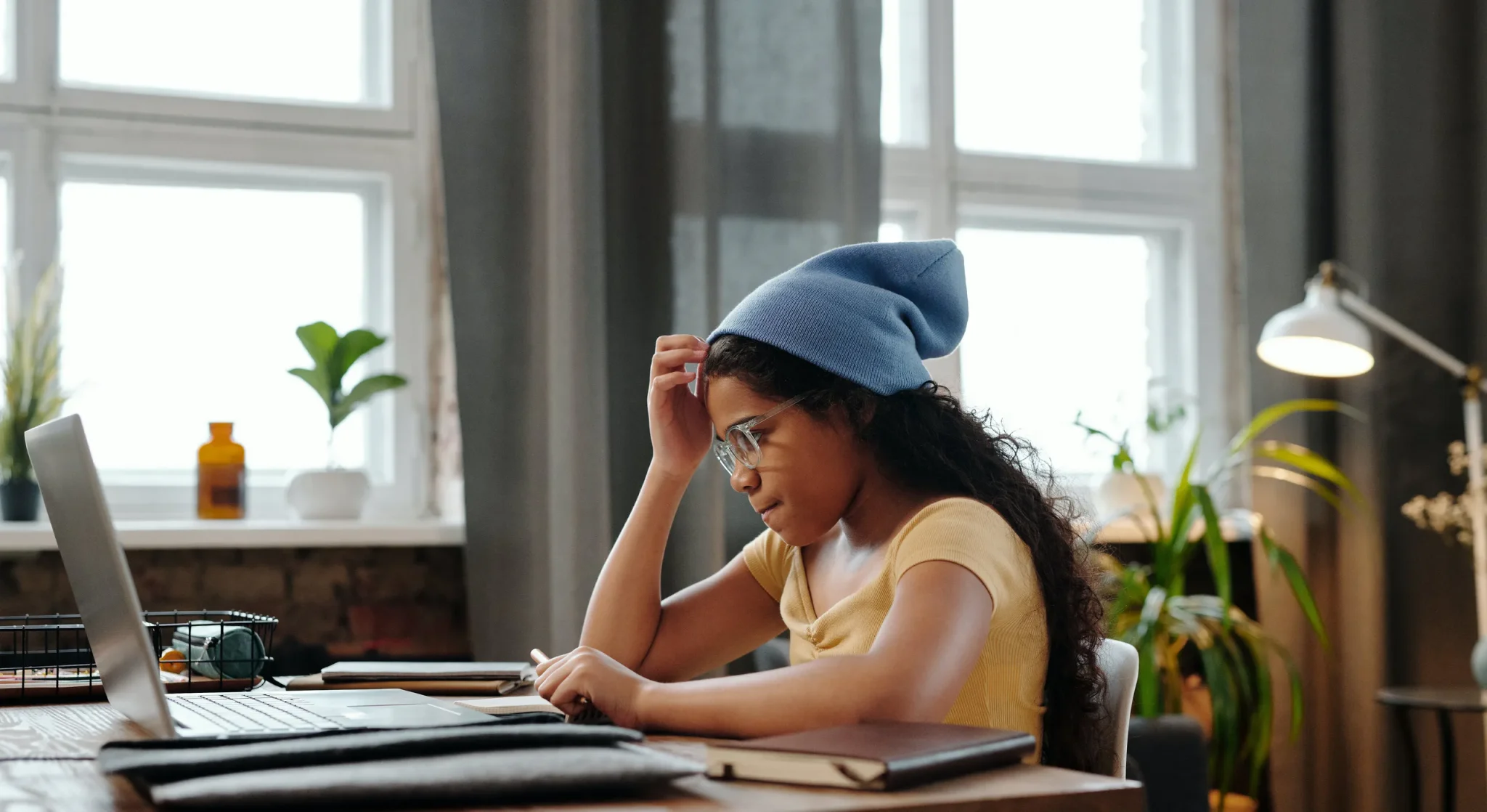 A child in front of a laptop thinking