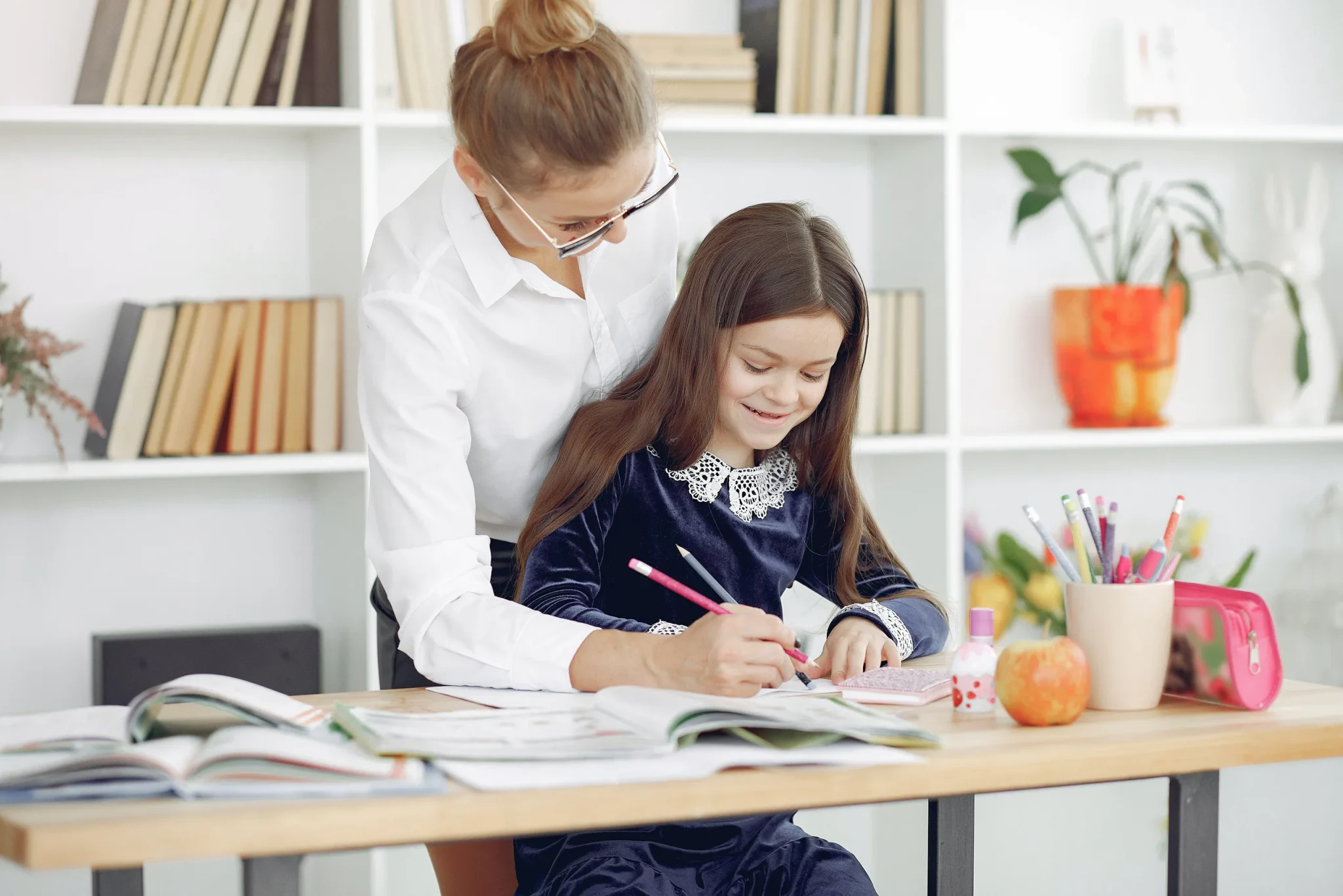 A tutor and a child writing