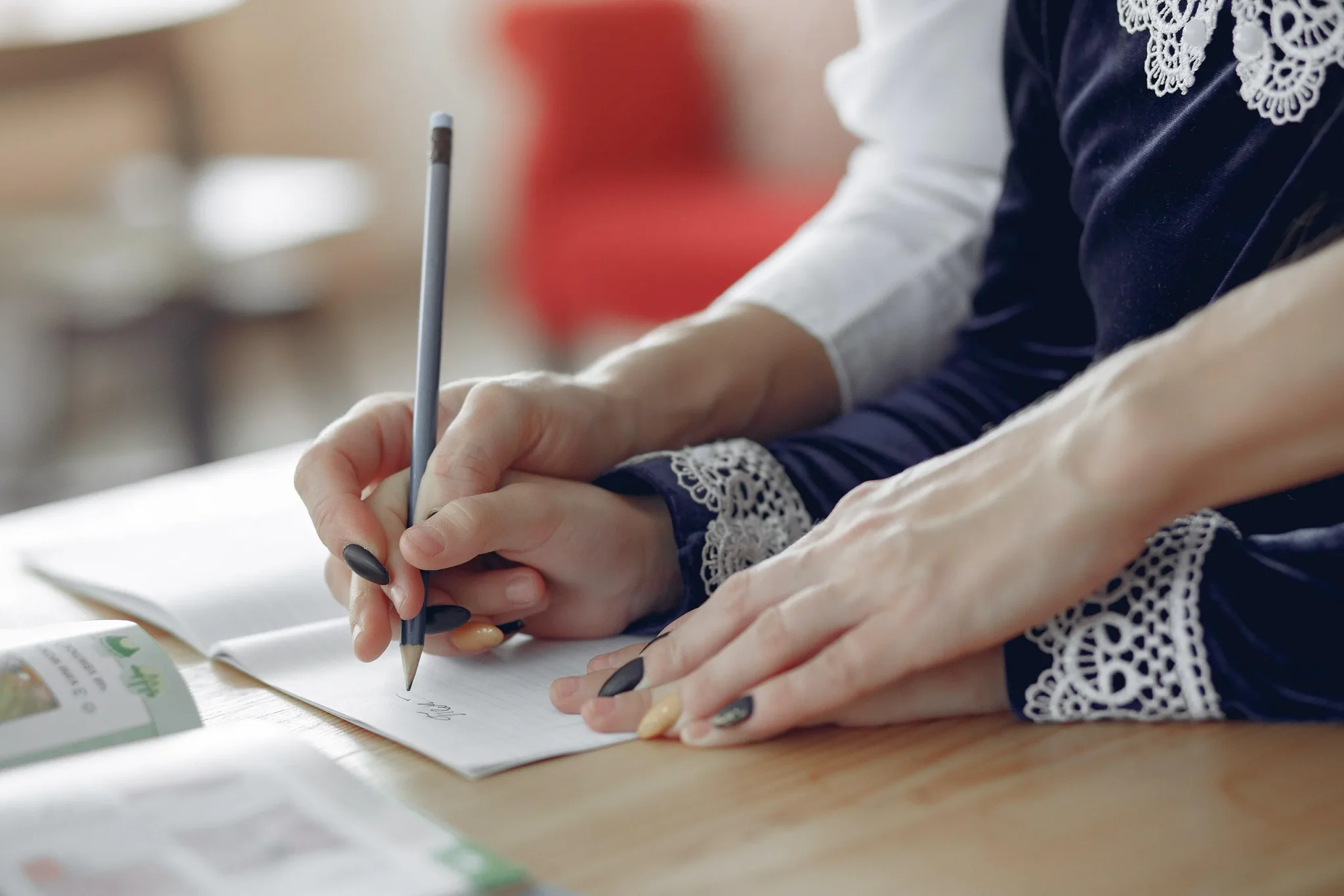 Someone holding the child of a hand while writing