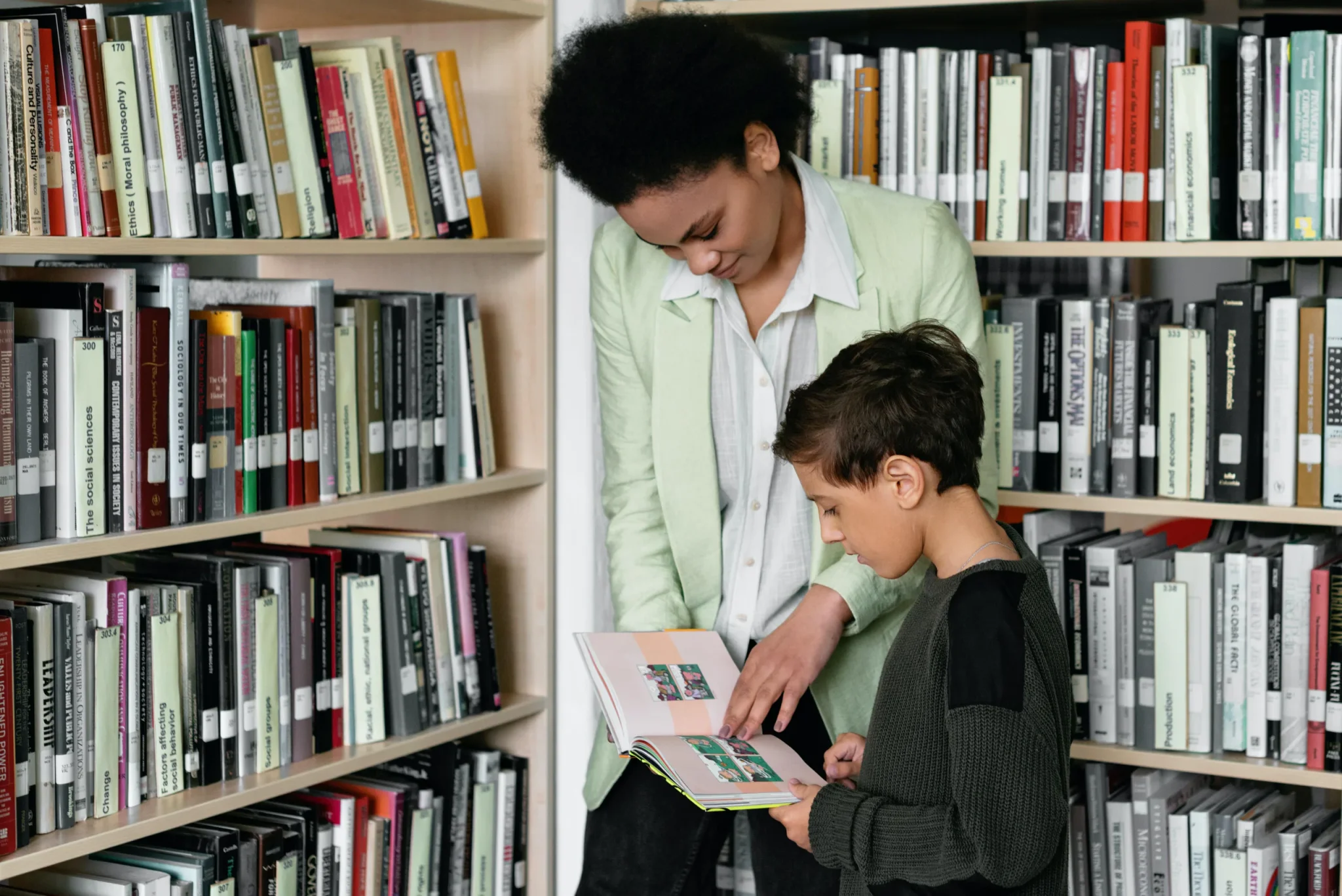 A mother showing her child a book in a library