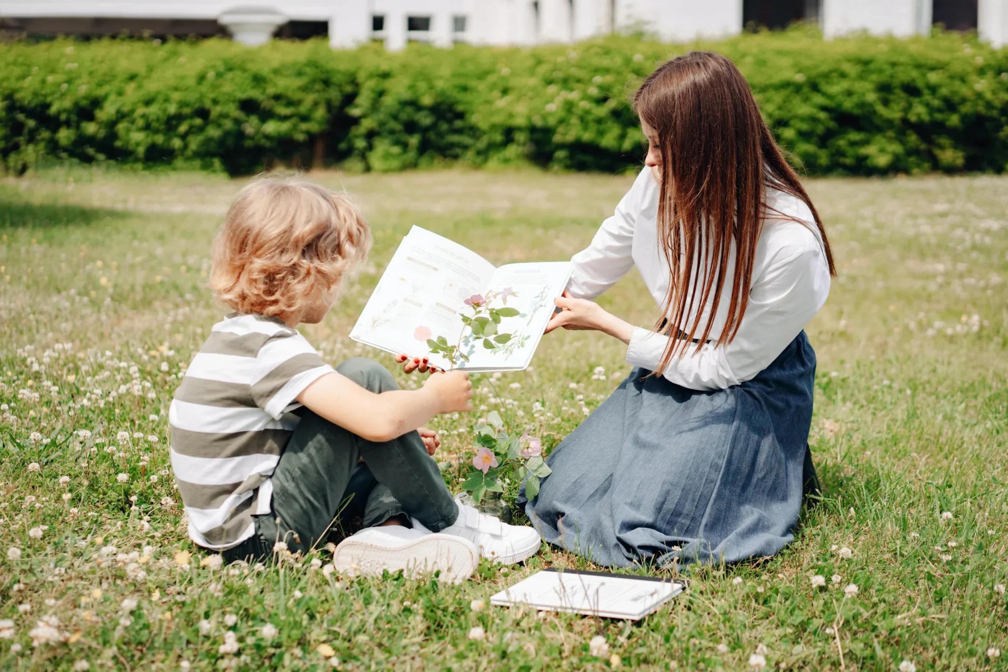 A woman holding up a book for her child to see