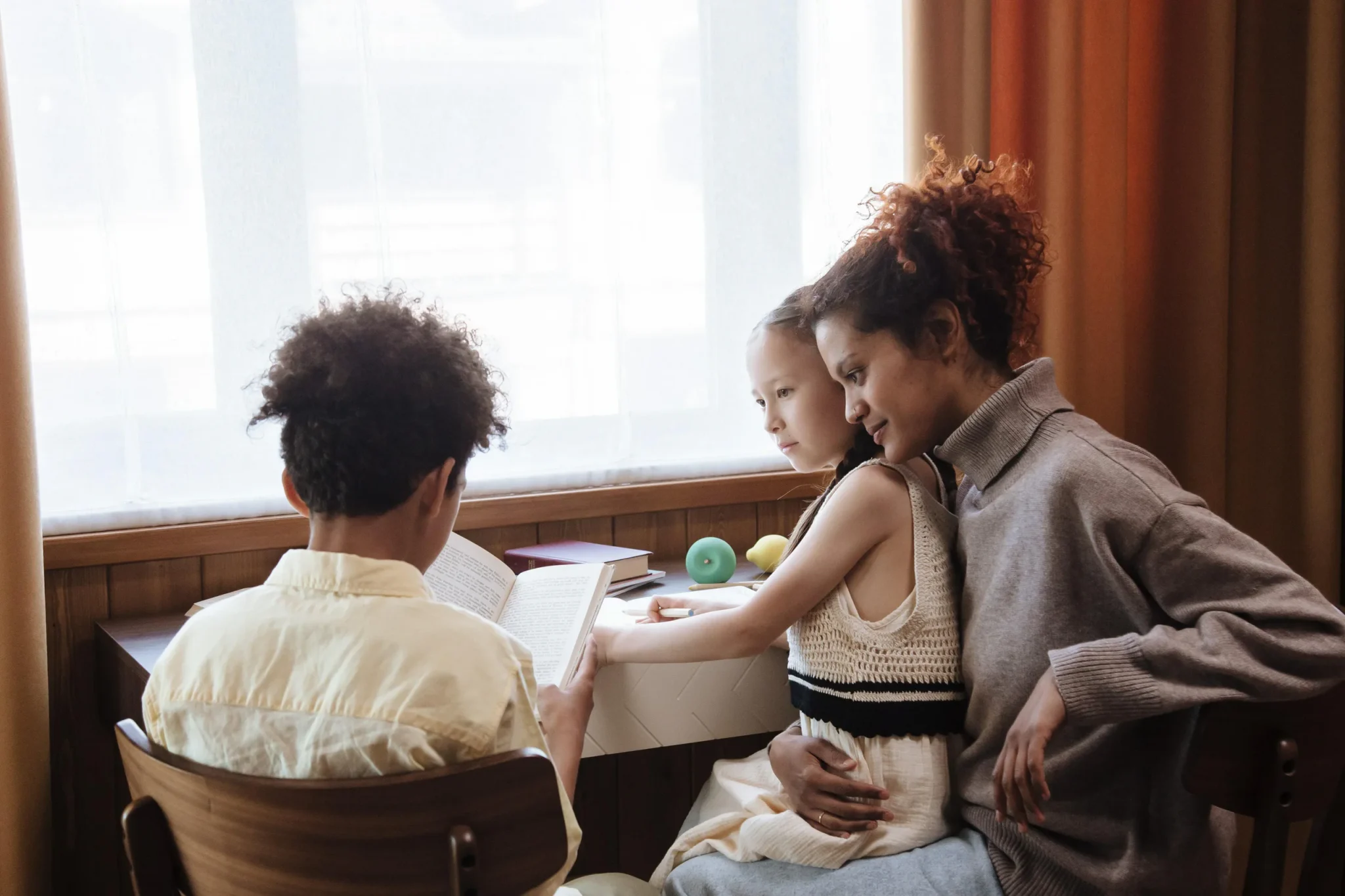 A woman and her children reading a book