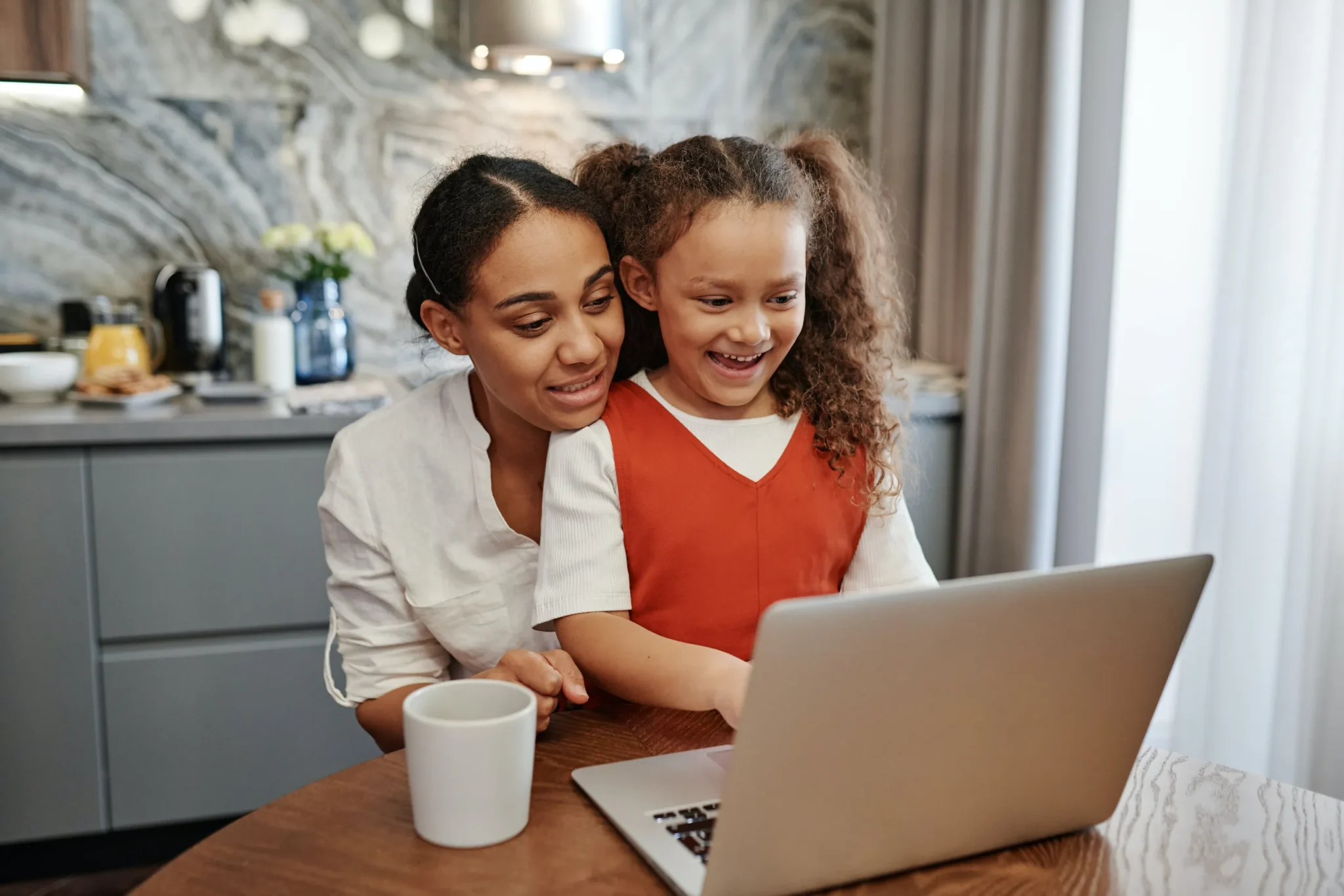 A mother and a child pressing a laptop