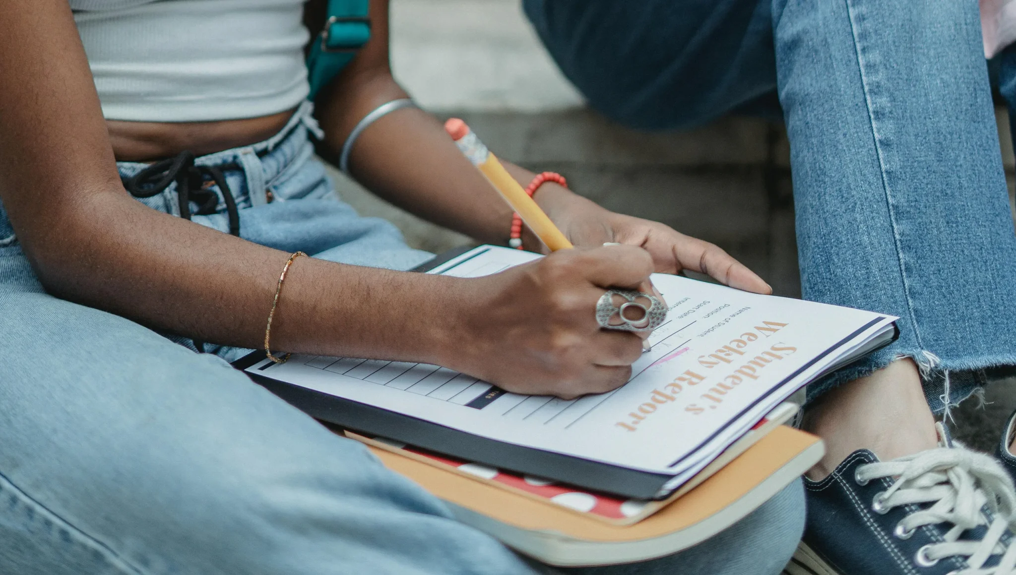 A person writing with a pencil