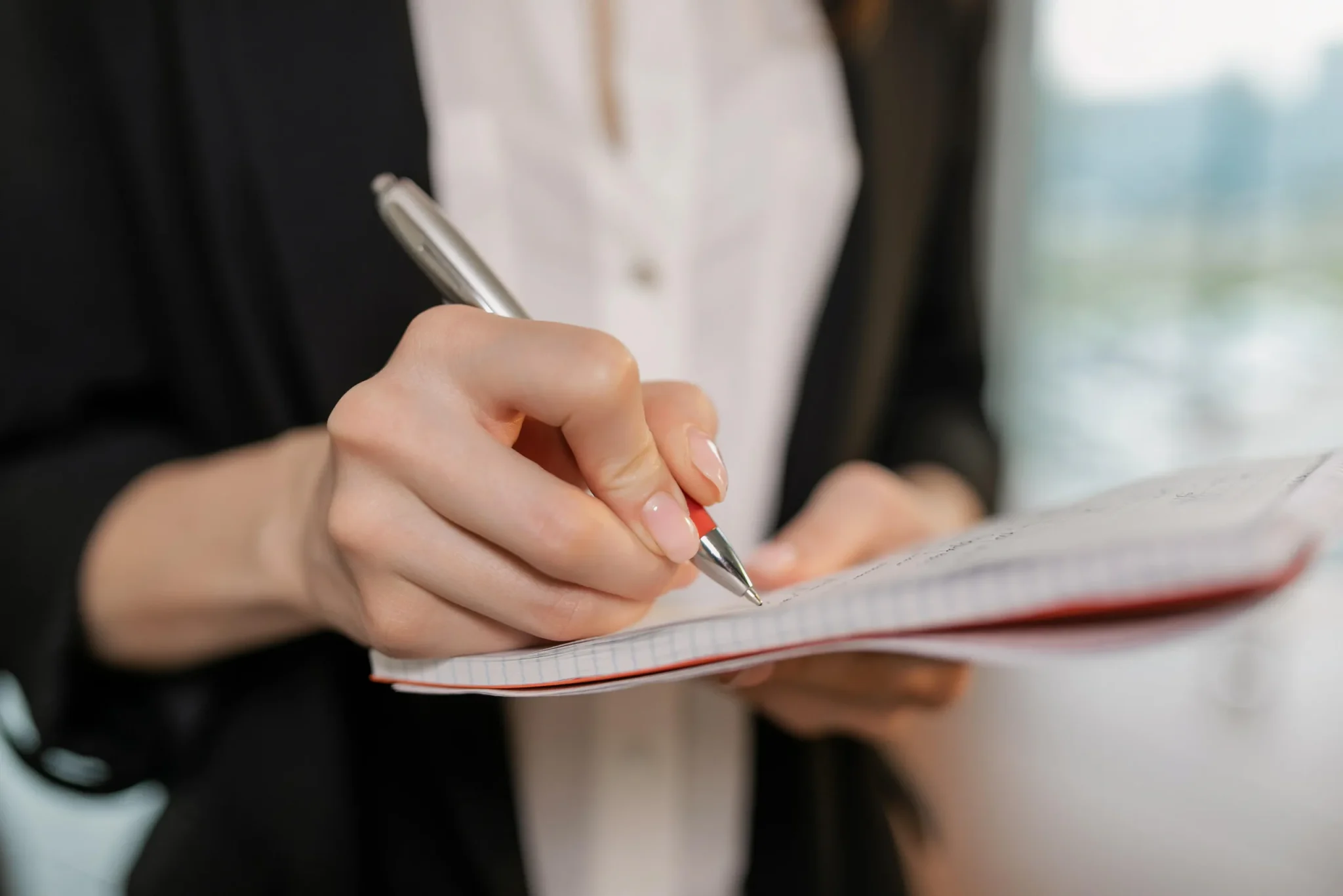 A woman writing down something on a paper