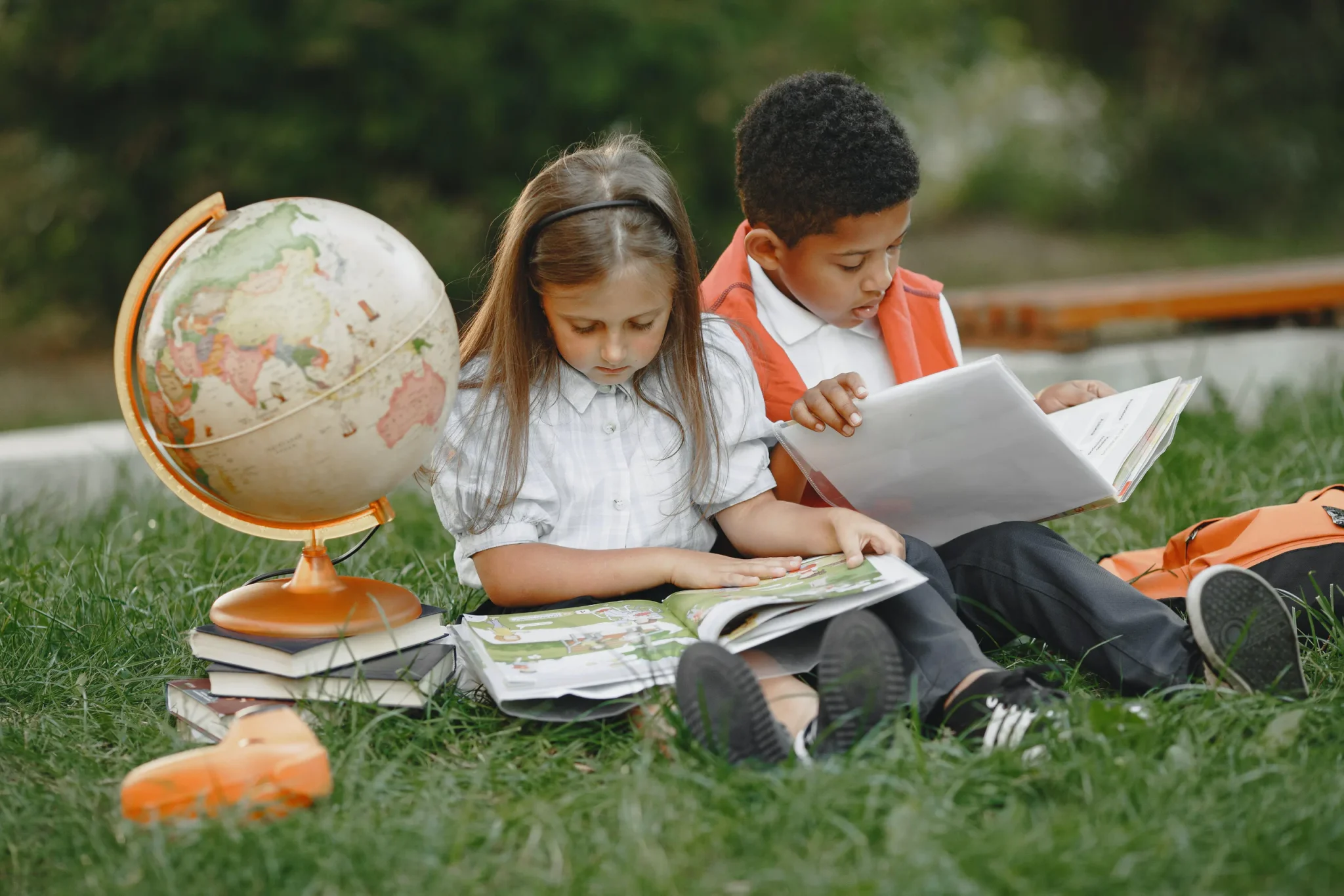 Two children studying on the grass