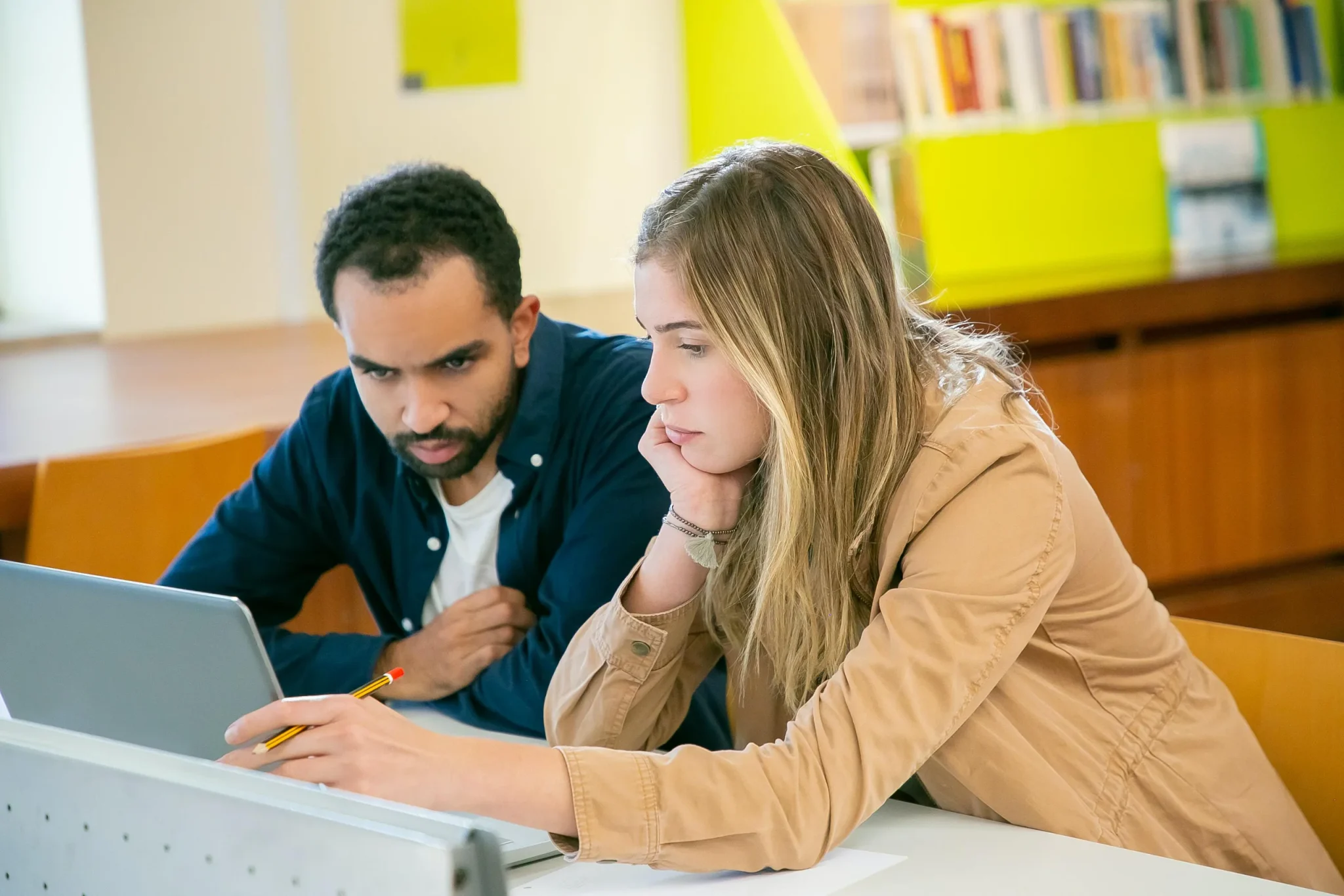 Two people looking at a laptop screen